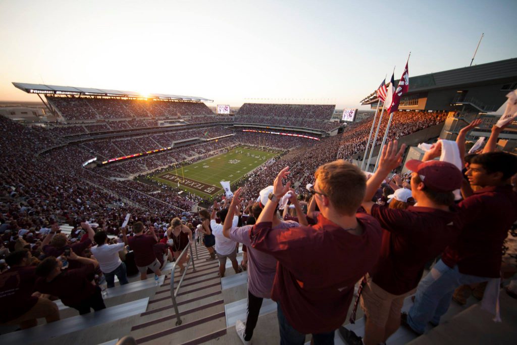 View of fans in Kyle Field during a game from the upper southeast corner of the stands as the sun sets.